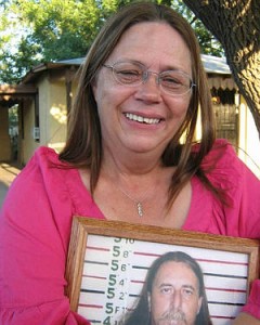 Prison wife holding mugshot photo